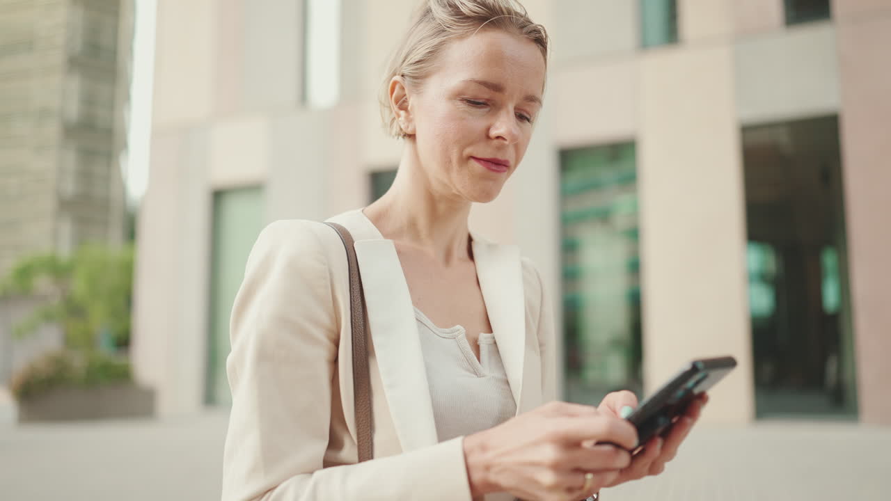 Donna d'affari che usa lo smartphone all'aperto