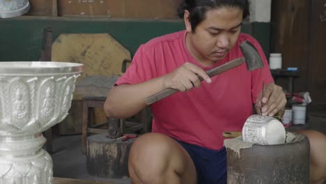 silver craftsman working on bowl