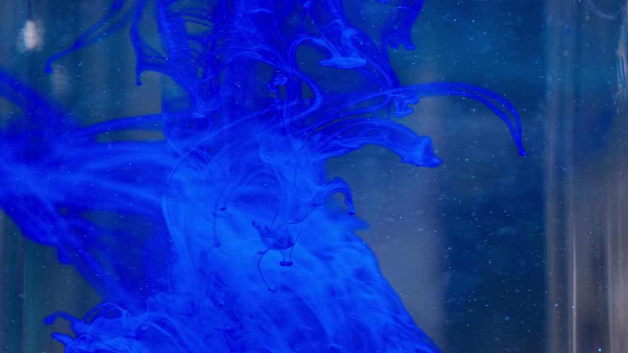 Inchiostro blu che turbina nell'acqua, creando un motivo rilassante e artistico