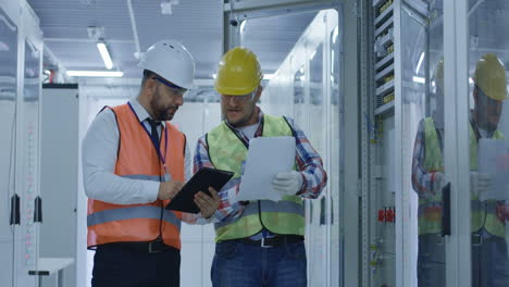 electrical engineers inspecting control panel