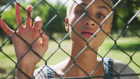 mixed race woman looking through a fence