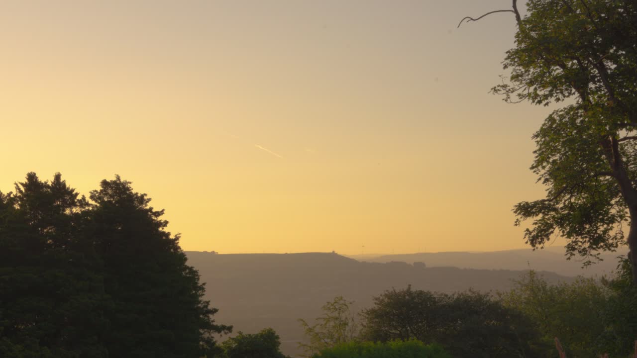 lento paso del tiempo al amanecer en el parque galés con árboles y niebla en el paisaje circundante