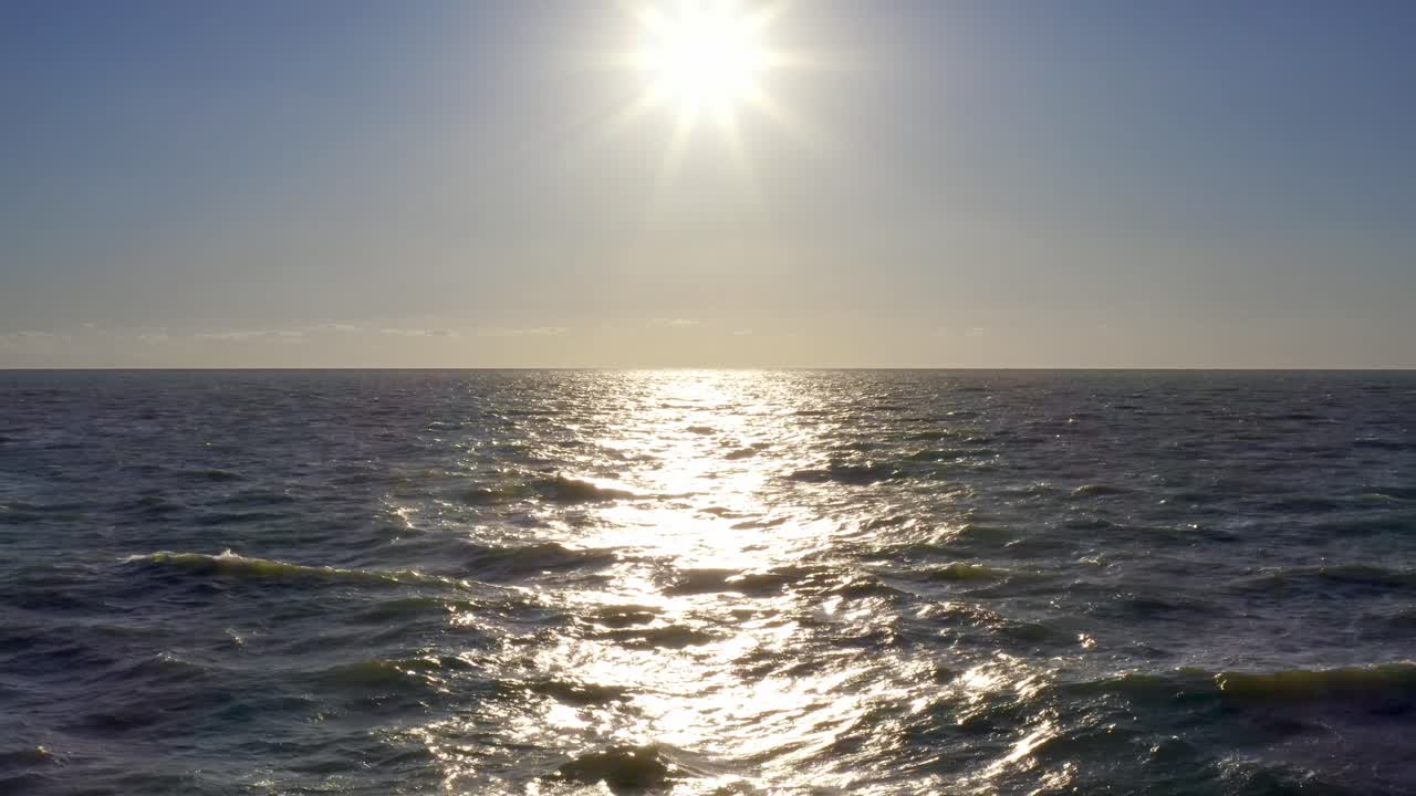 무인 항공기 4k 저고도가 황금빛 파도를 넘어 태양 설정으로 밀어 넣습니다.