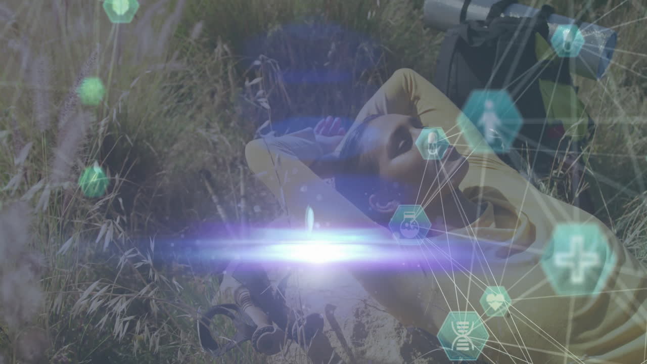 Woman lying on grassy meadow, with health tech icons and DNA strand floating under lens flare