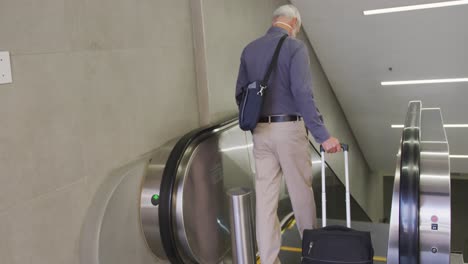 caucasian man out and about in a metro station wearing on a face mask against coronavirus