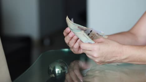 woman checking money colombian currency bills to pay bills