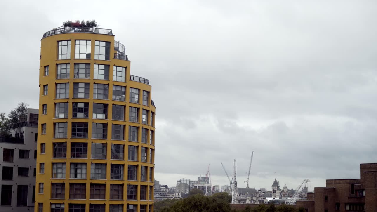 edificio amarillo moderno en el paisaje urbano de londres con sitio de construcción