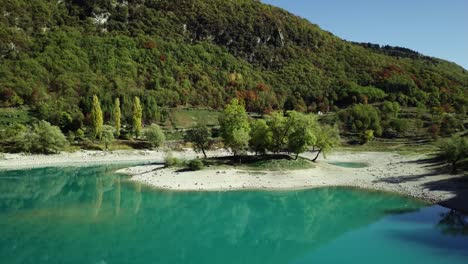 lago de agua azul de montaña en los alpes italianos dolomitas con árboles y picos drone órbita aérea alrededor