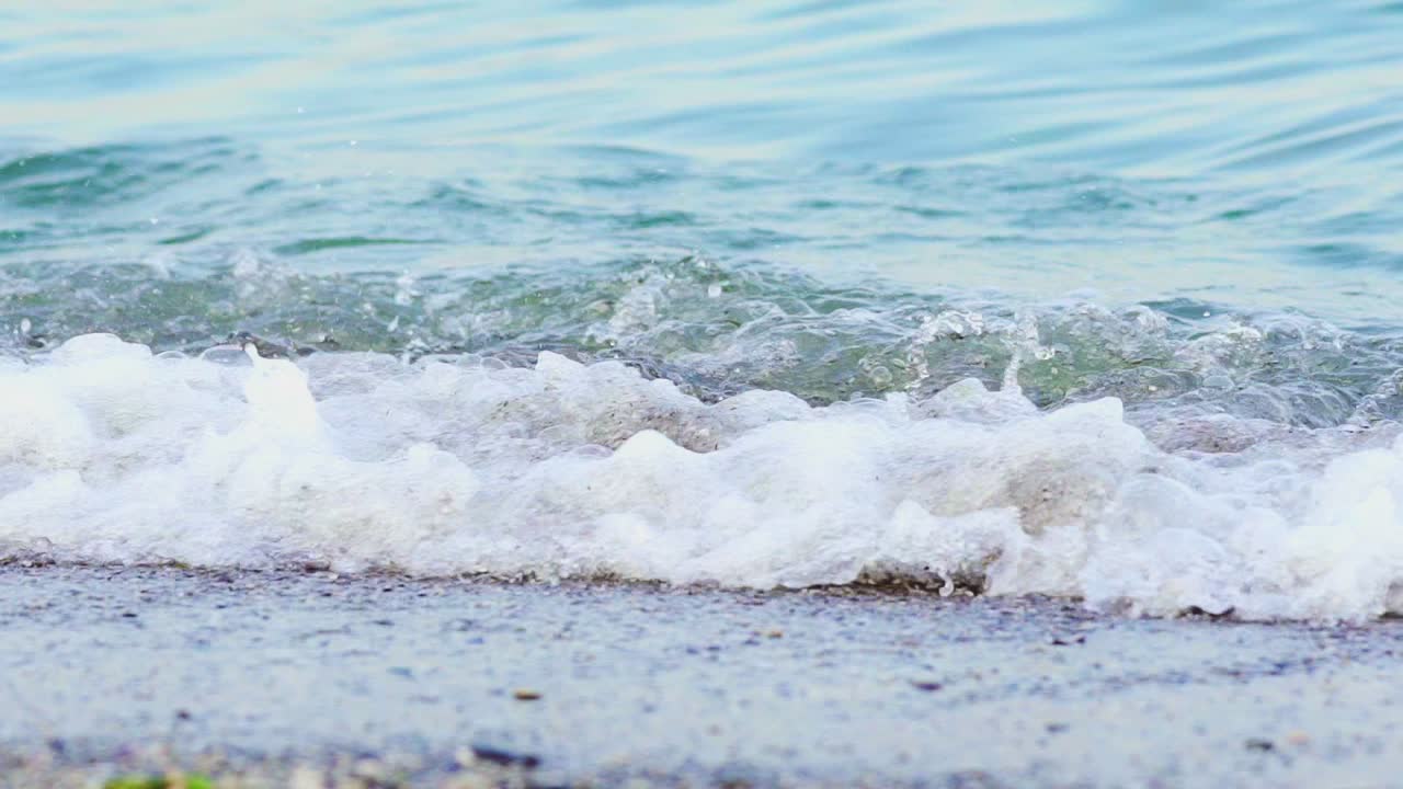 Natural sea marine oceanic background with big waves forming white foam on the shore. Close-up beach of blue water waves crashing.