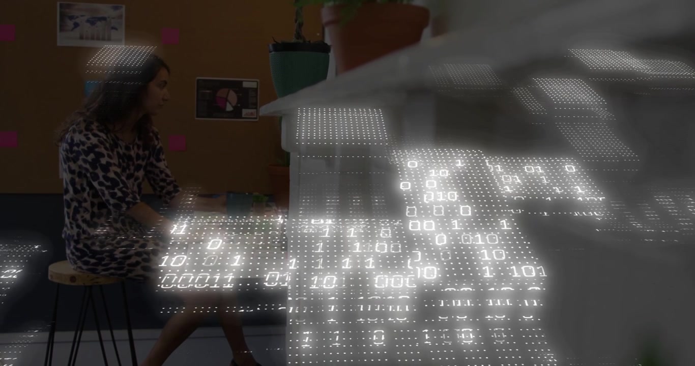 Woman at counter sipping mug and sorting notes, binary grid appearing from right, showing tech data