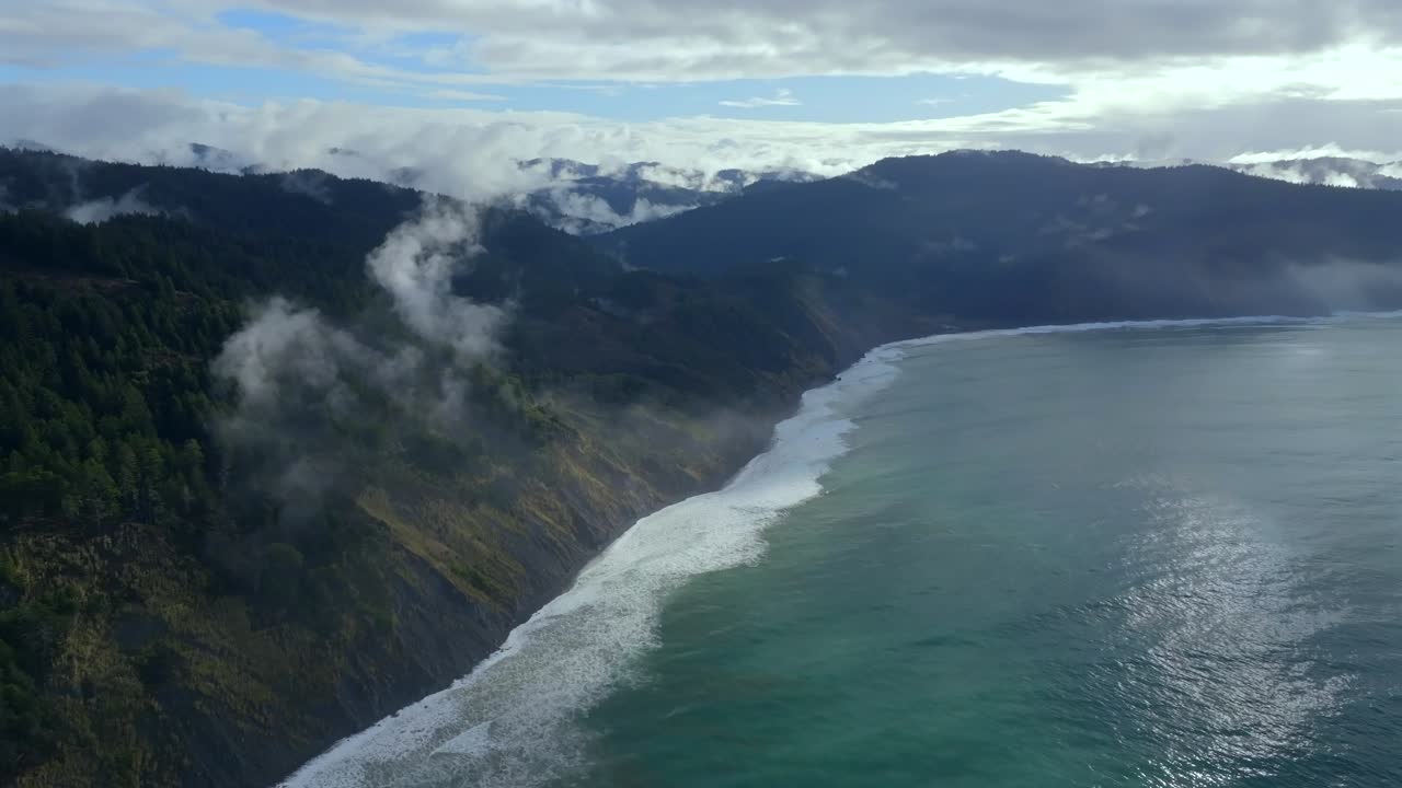 Rugged coastline Lost Coast Trail USAL Beach campground 4wd black sand mist rain fog aerial drone California PNW sun rays waves crashing cloud layer morning Chimney Rocks forward motion