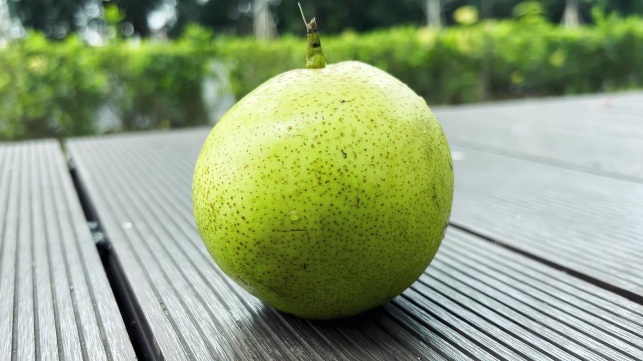 Pera verde fresca appoggiata su una superficie di legno all'aperto