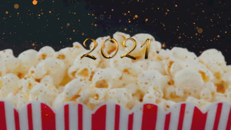 animation of 2021 over popcorn on black background