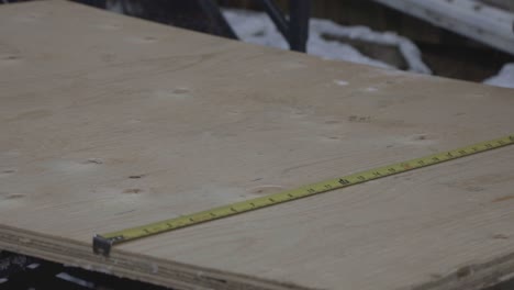 Measuring-The-Height-Of-The-Wood-Plank-Using-A-Tape-Measure