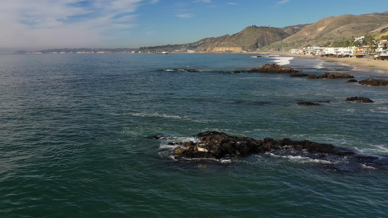 olas gigantes rompiendo en acantilados rocosos con espuma blanca salpicada