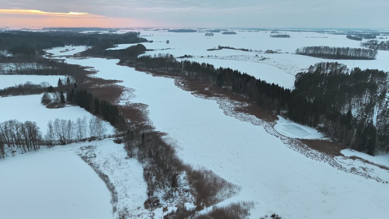 Панорама с дрона заснеженного ландшафта Тервете на закате. Зимние леса и поля под драматическим вечерним небом.
