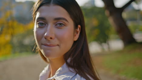 serene woman basking sunlight at beautiful park. closeup relaxed girl face