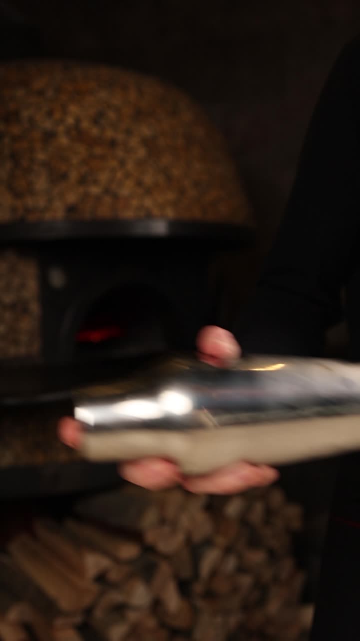 Barman che prepara un cocktail vicino a un forno per pizza