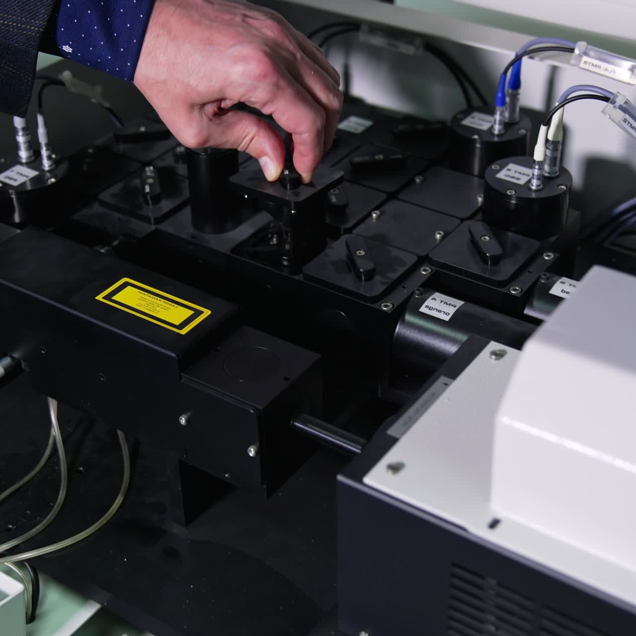 Man's hand takes out a part of medical equipment. Technological devices for conducting research experiments in medical laboratory. Close up with gradual distancing