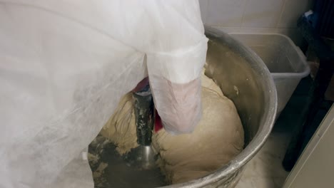 the-baker-adding-flour-to-the-kneaded-dough