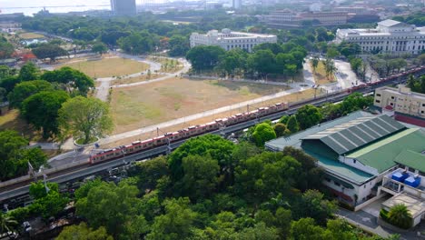 aerial view of passing trains at rizal luneta park in capital city metropolis of manila, philippines