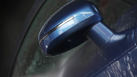 detalle del espejo de un audi tt azul siendo lavado con agua a alta presión