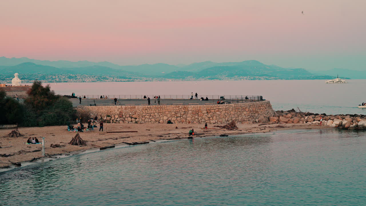 Scenic coastal view of people at a beach Antibes, France at sunset