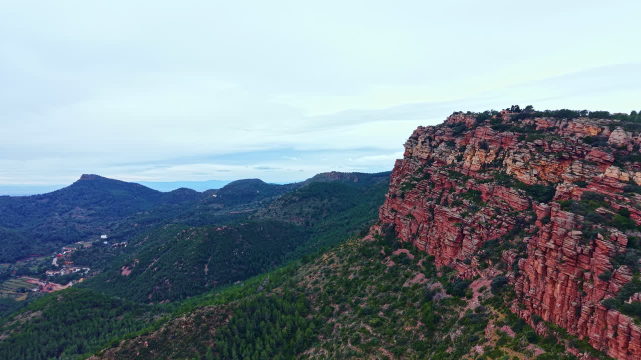 Veduta di colline e montagne rocciose sotto un cielo nuvoloso in un paesaggio naturale di giorno in una zona rurale.