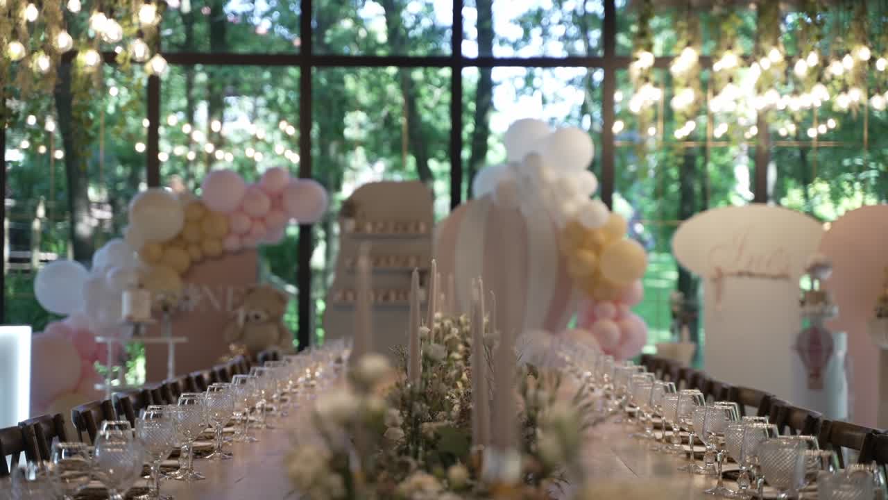 Allestimento sontuoso per banchetto nuziale con palloncini rosa e bianchi, composizioni floreali rigogliose e illuminazione elegante