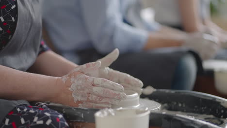 close-up of the hand of a master working on a potter's wheel for the manufacture of clay and ceramic jugs and plates in slow motion