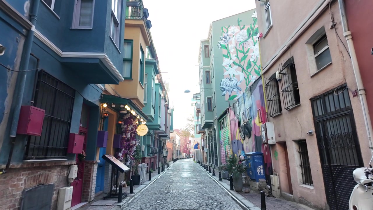 Stretta strada acciottolata con edifici colorati e street art a Istanbul