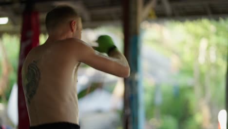 man with tiger tattoo training in a martial arts gym