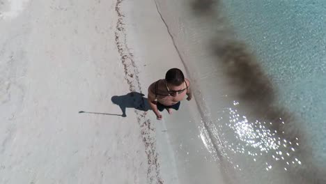 hombre caminando por la orilla de la playa