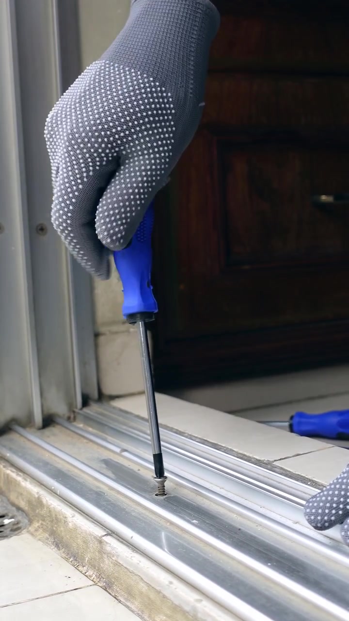 Pessoa Usando Chave de Fenda para Apertar Parafuso na Moldura da Porta