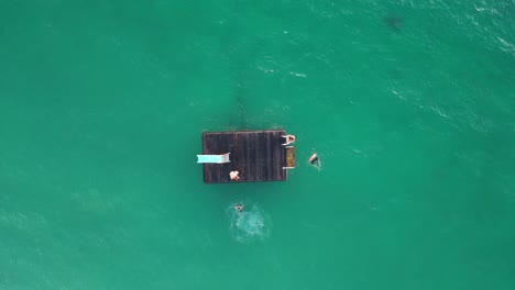 People-Jumping-From-Floating-Platform-In-Coogee-Beach,-Perth-City