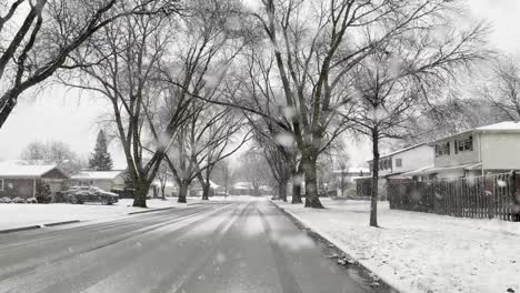 Looking-at-snow-falling-in-a-neighborhood-street-during-the-day