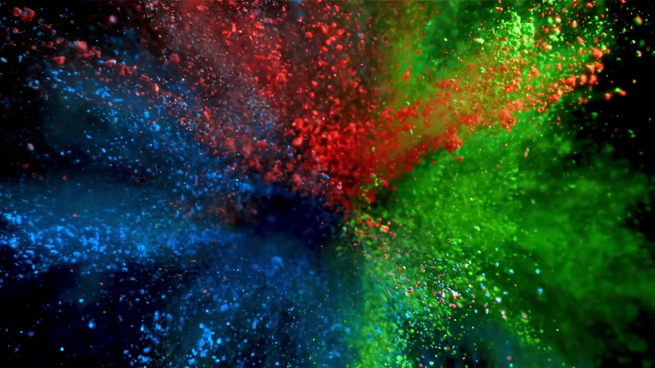 Esplosione di polvere vibrante rossa, verde e blu al rallentatore