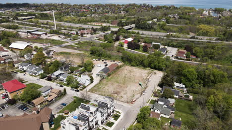 Aerial-tilt-up-shot-of-Grimsby-Village-near-of-highway-and-blue-Ontario-Lake-in-background,Canada