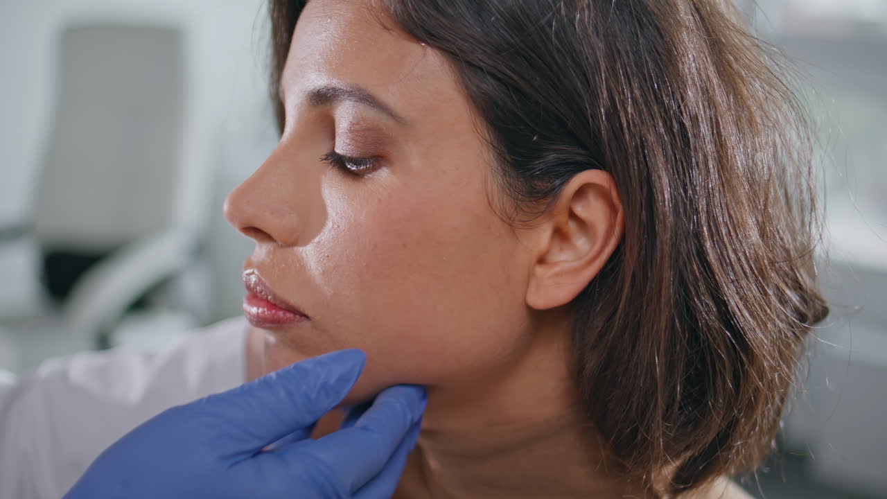 Physician checking lymph node on clinic patient closeup. Medical professional