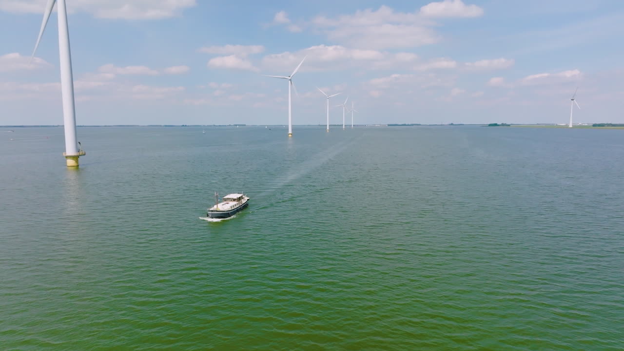 ship crosses the sea under wind turbines in the North Sea in Netherlands