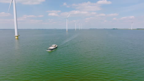 ship crosses the sea under wind turbines in the north sea in netherlands