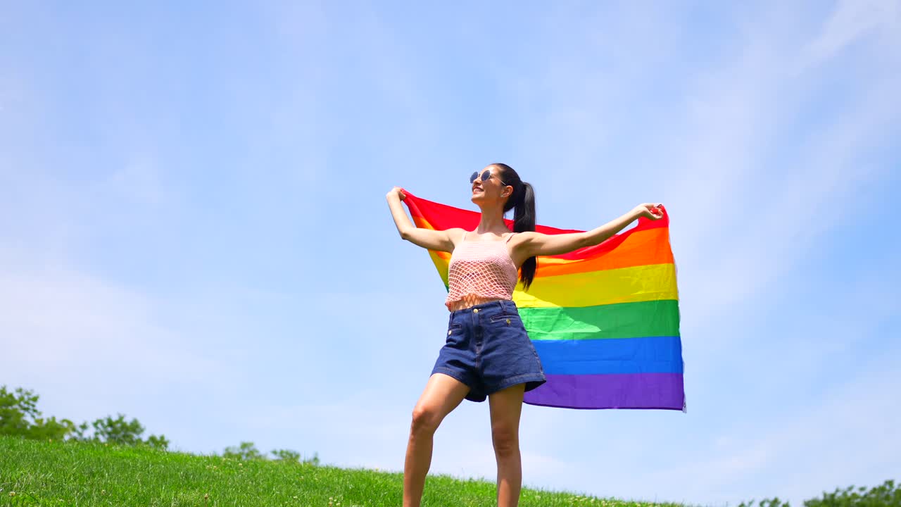 Woman holding a pride flag outdoors