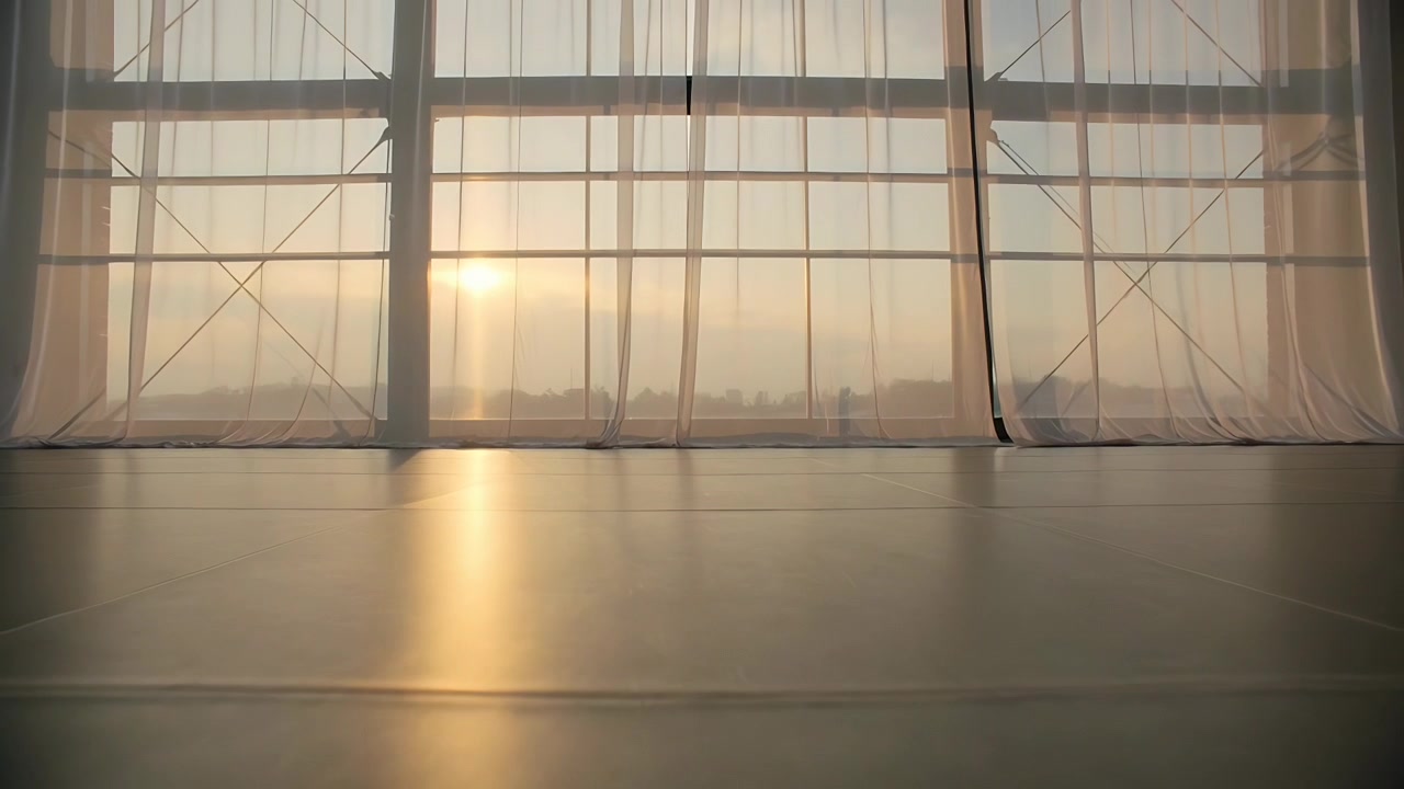 Il sole che sorge proietta un'alta riflessione sul pavimento dello studio, con finestre e tende trasparenti che si muovono.