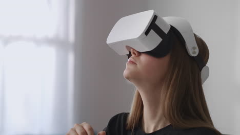 Weibliche-Benutzerin-Verwendet-Ein-Neues-Head-Mounted-Display-Zum-Spielen-Von-Spielen,-Sitzt-Im-Wohnzimmer-Und-Bewegt-Die-Hände,-Um-Moderne-Technologie-Zu-Steuern