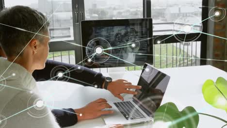 animation of network of profile icons over diverse man and woman discussing over a laptop at office