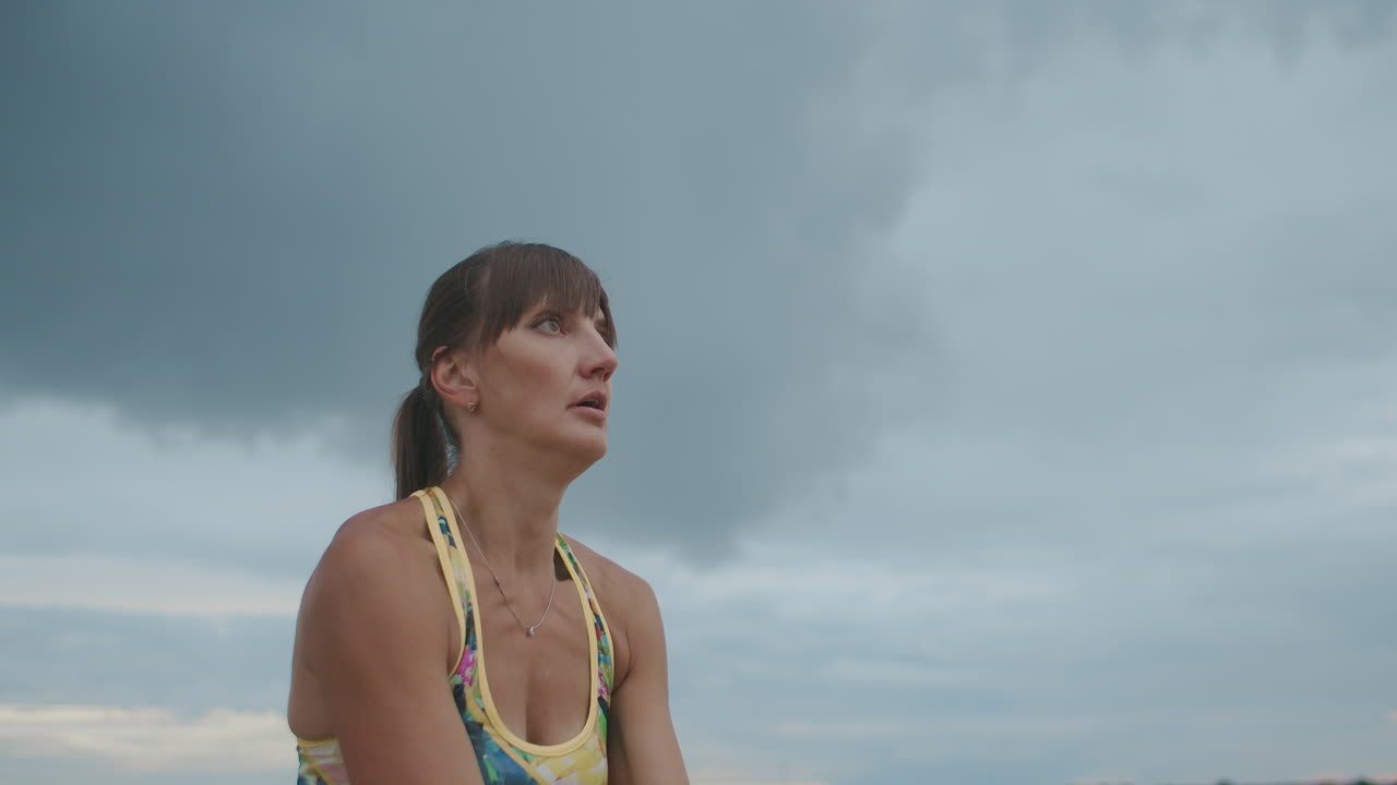 una deportista activa está jugando al voleibol de playa golpeando la pelota para servir el retrato de meduim en movimiento