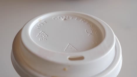 close-up of a white disposable coffee cup lid