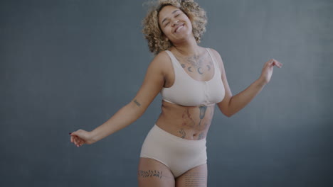 happy plus-size woman dancing in lingerie