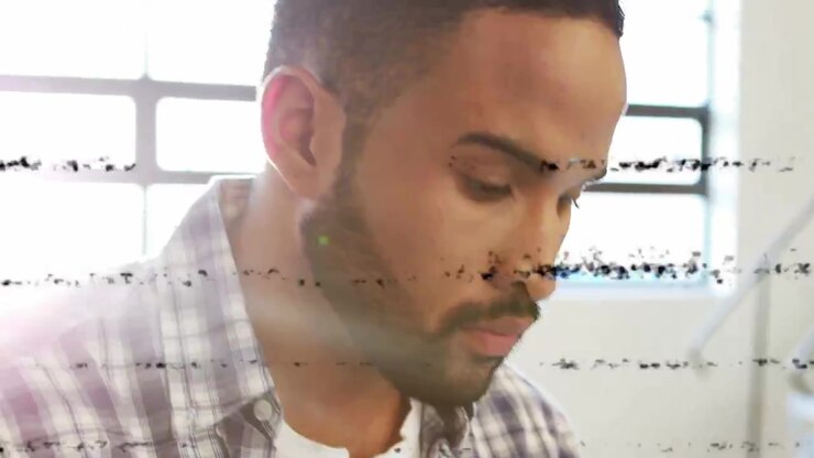 Uomo adulto che si sporge in avanti e tocca un tablet mentre le linee di disturbo si dissolvono, testando un'interfaccia tecnologica.