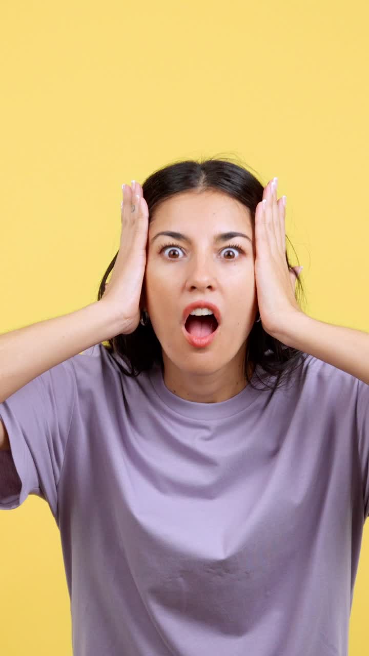 Woman showing a surprised or shocked expression against a yellow background